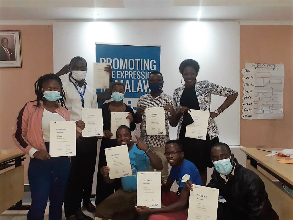 A group of journalists displaying their certificates after the training